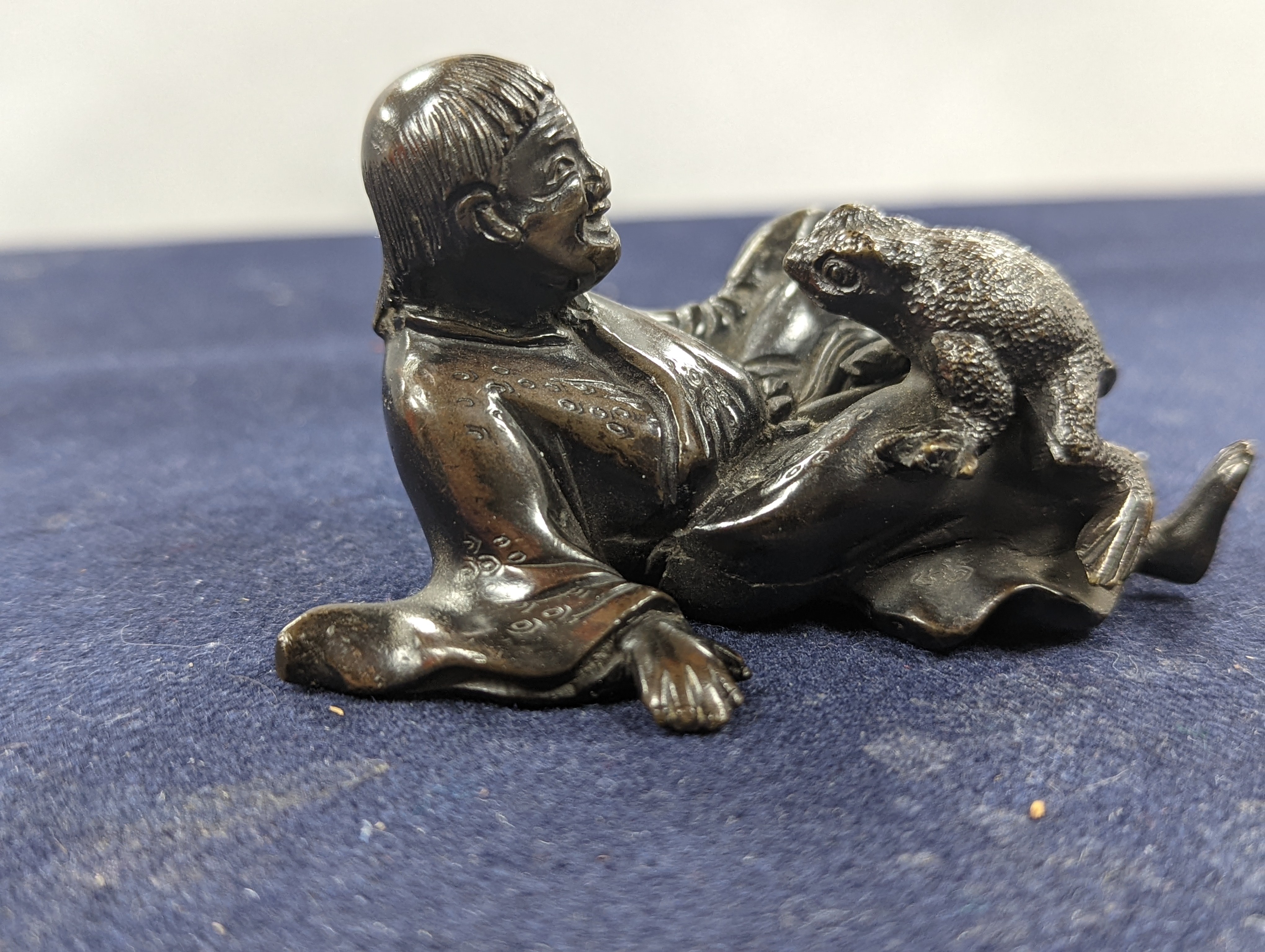 A Chinese bronze group of Liu Hai and a toad, wood stand and a bronze figure of a dog, 9cm
